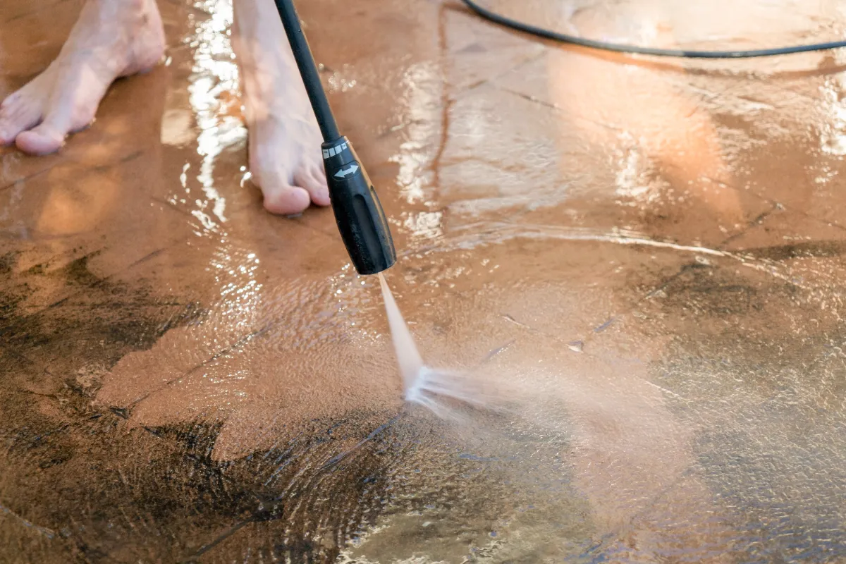 Washing and removing the dirty mold and dirt on the cement using pressure washer.